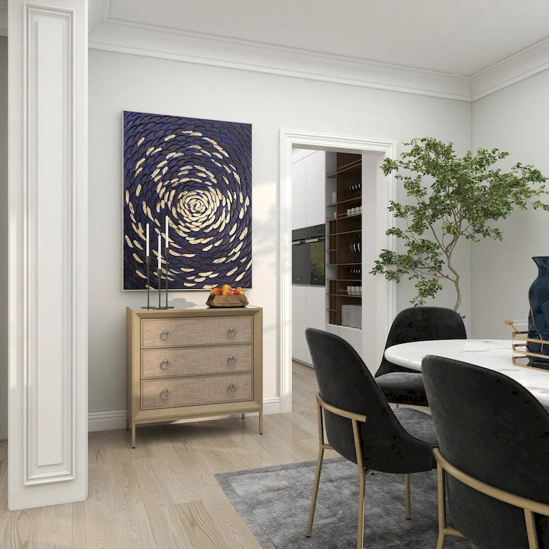 Commode en bois à trois tiroirs avec finition capitonnée, plateau miroir et poignées anneaux.