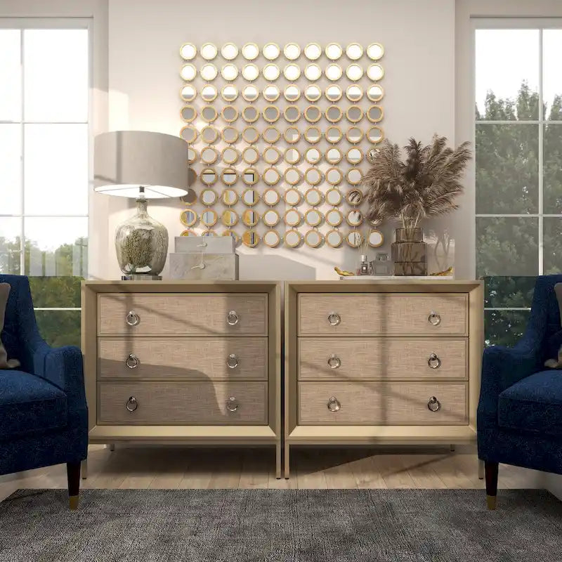 Commode en bois à trois tiroirs avec finition capitonnée, plateau miroir et poignées anneaux.